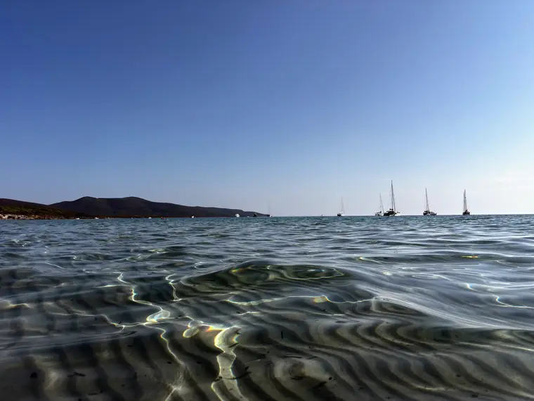 Mare piatto nelle giornate senza vento, con la costa del poligono all'orizzonte.
